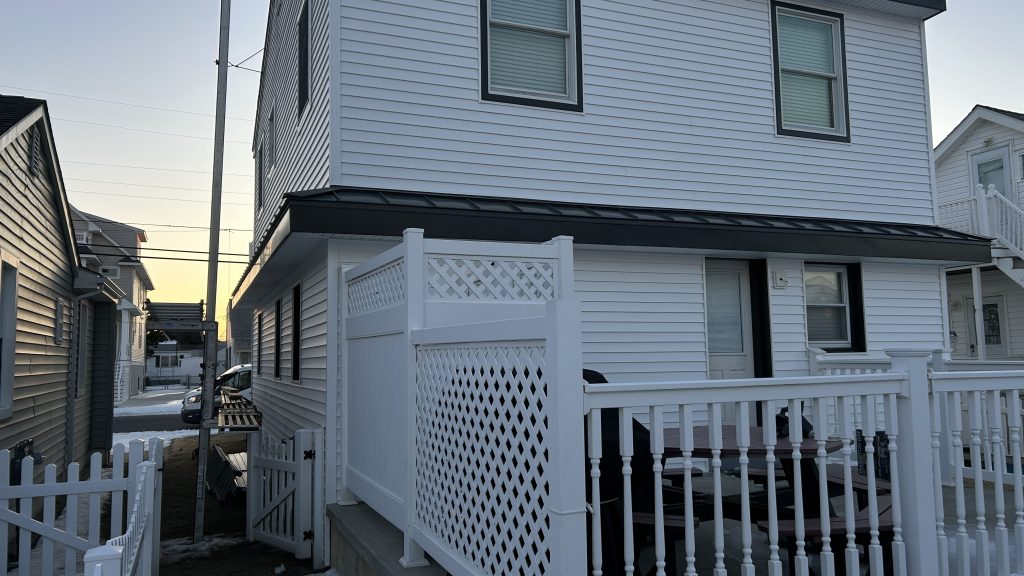 Roof Replacement Cost in Bucks County, PA: 2026 Pricing Guide 3 Black metal standing seam roof with new vinyl siding by YBR GROUP Inc in Bucks County PA